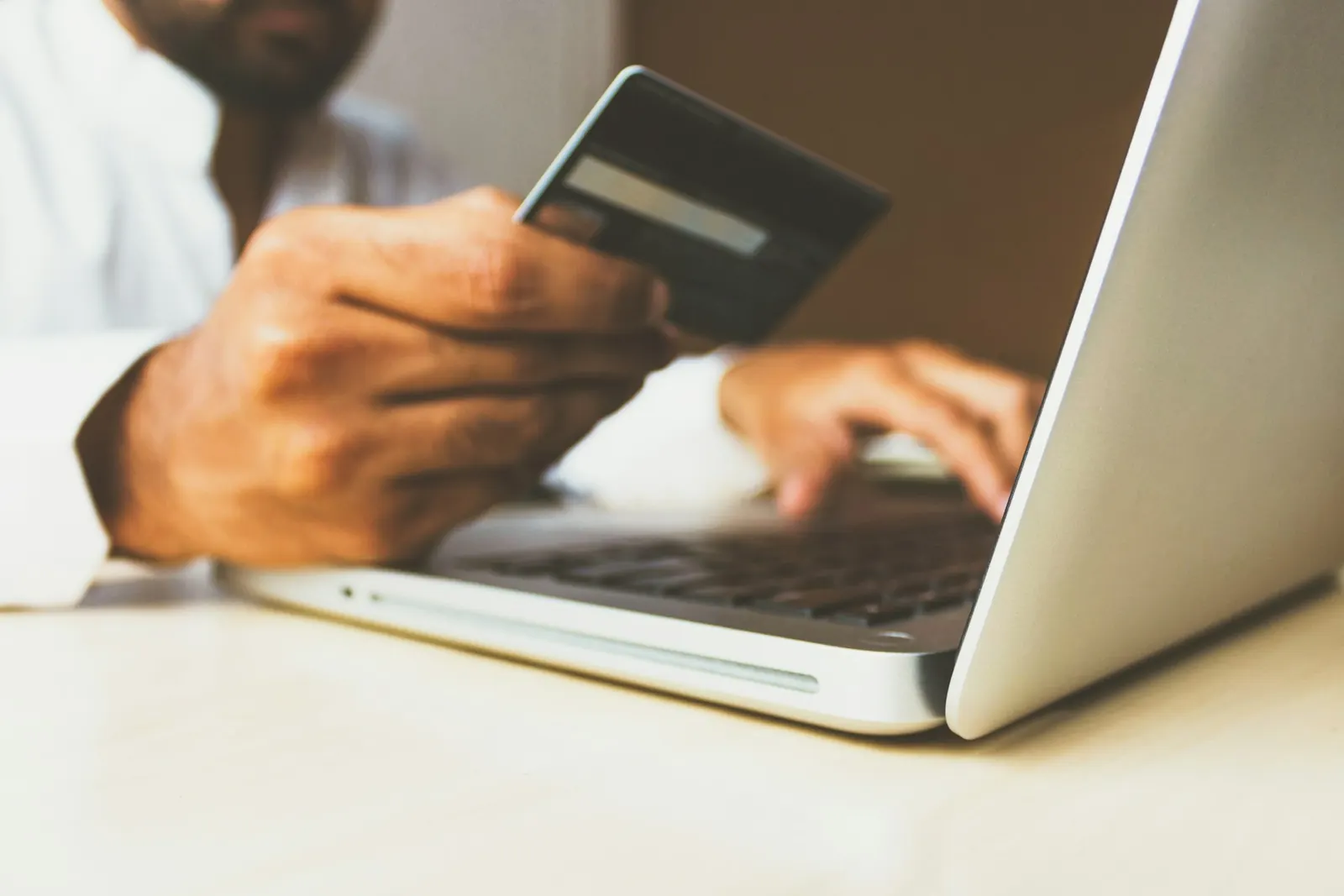person inputting credit card numbers into computer 
