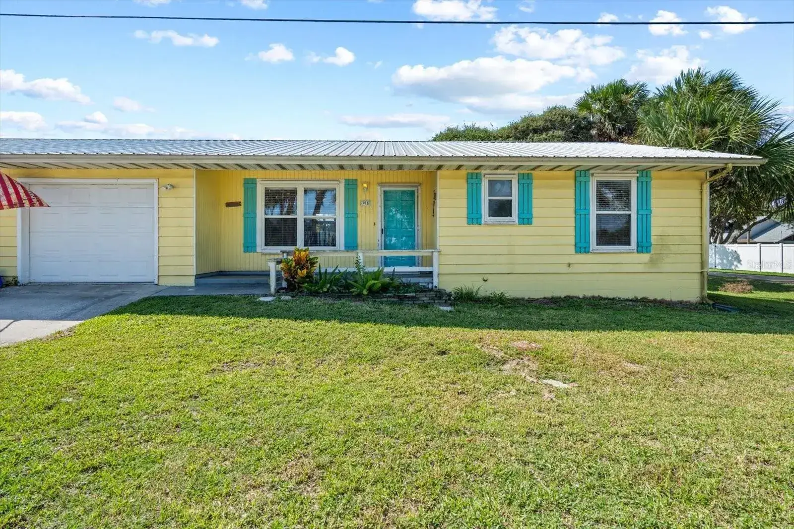 Yellow beach cottage with teal shutters in Flagler Beach