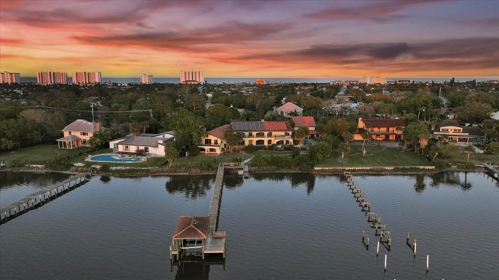 Aerial view of riverfront homes and docks in Ormond-by-the-Sea at sunset