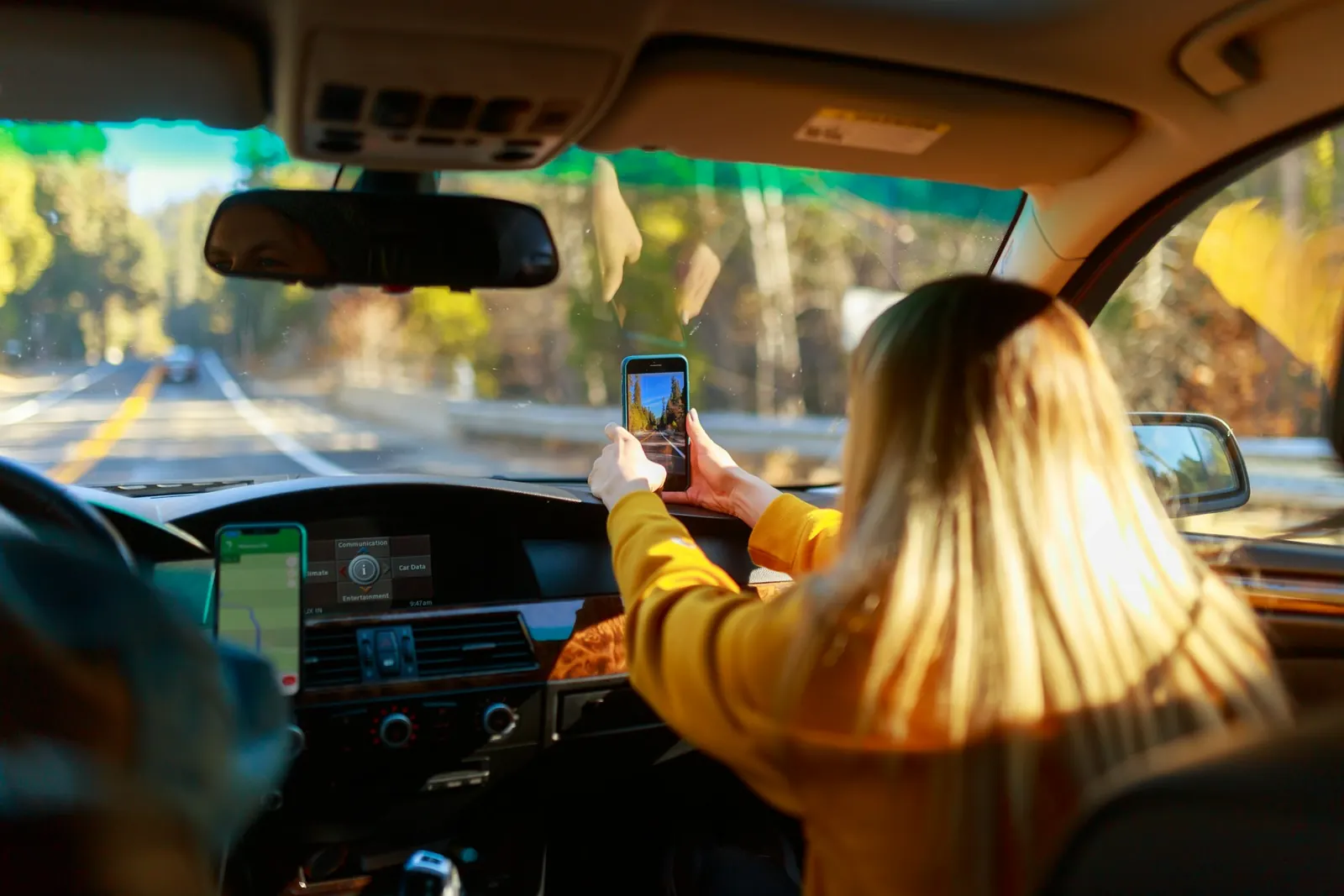 girl holding phone in car