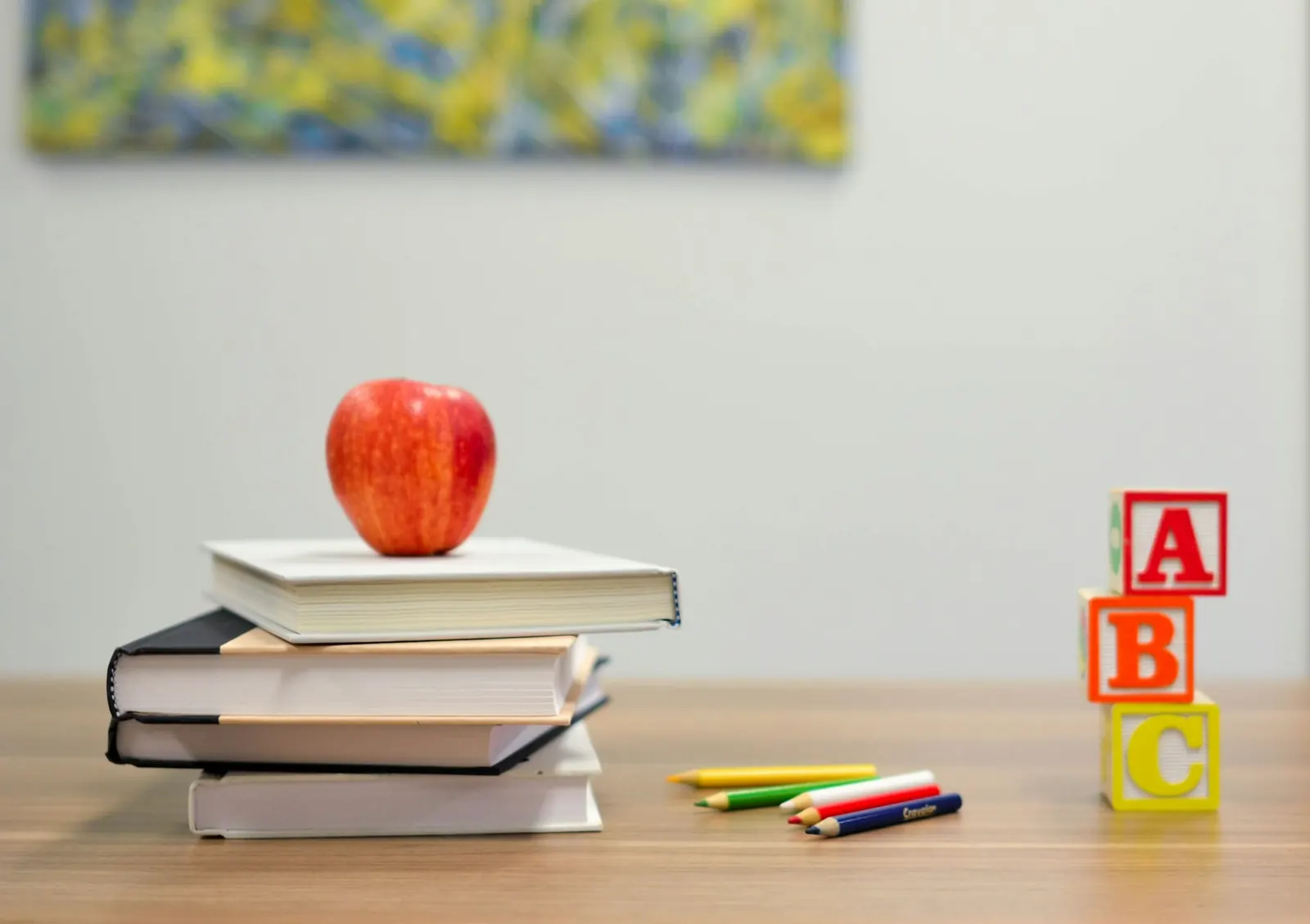 apple sitting on top of textbooks at a school